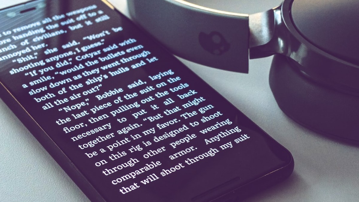 black smartphone near Skullcandy headphones