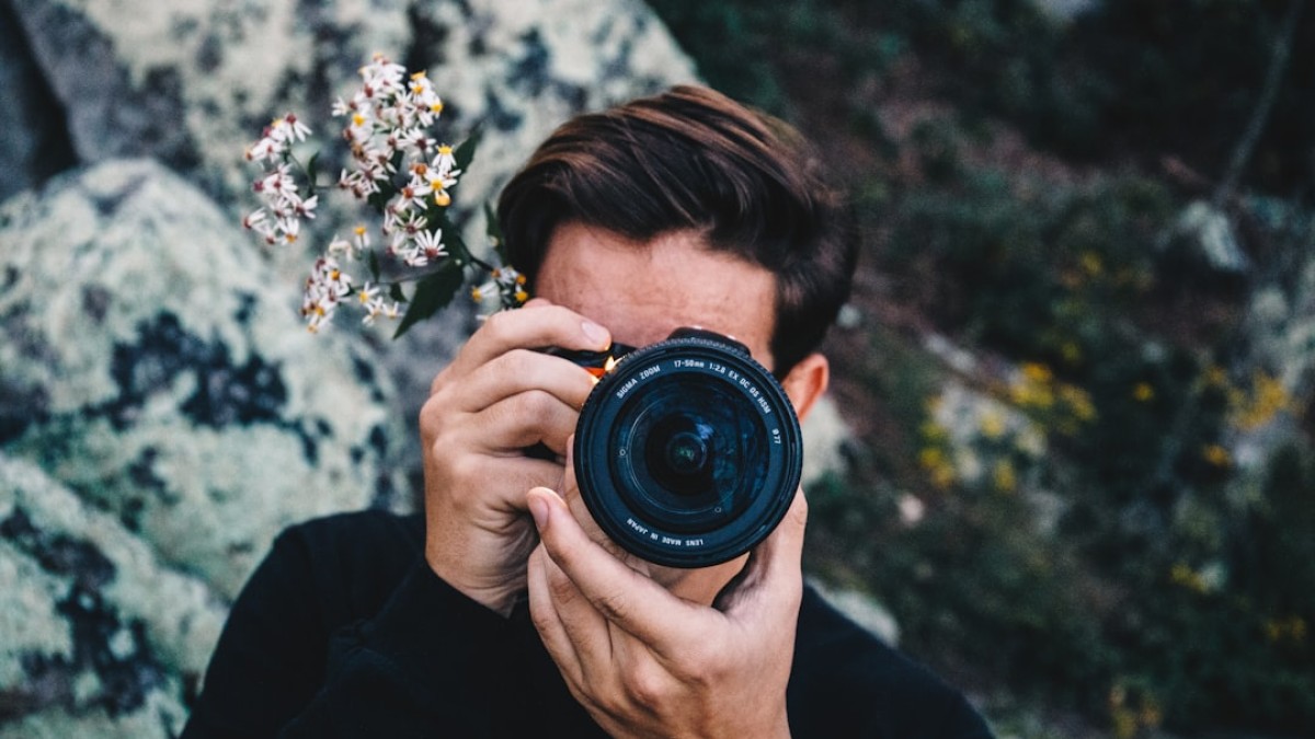man in black long sleeve shirt holding black camera