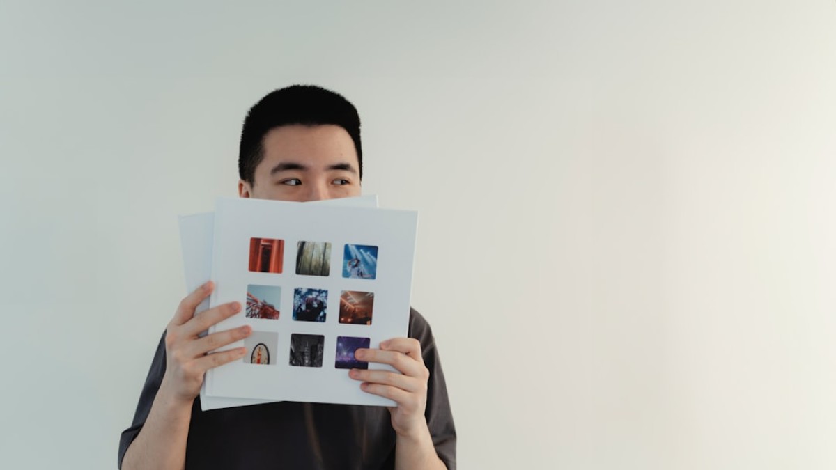 A man hiding his face behind a book