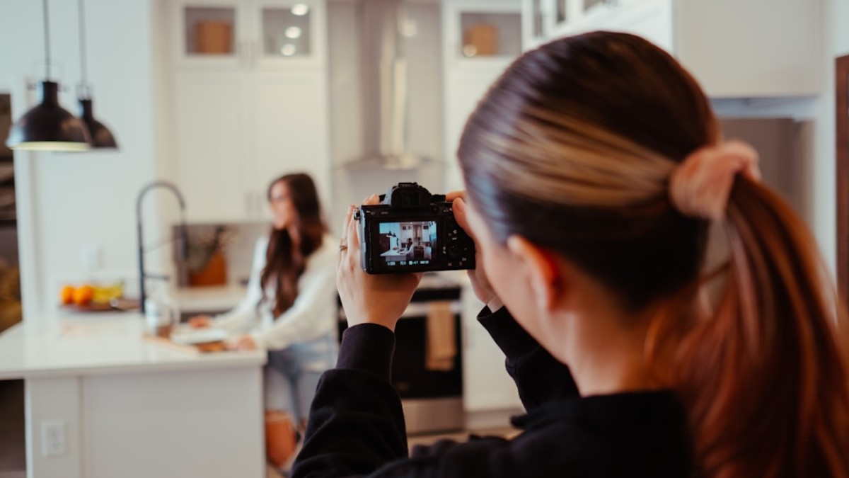a woman taking a picture of herself in a kitchen
