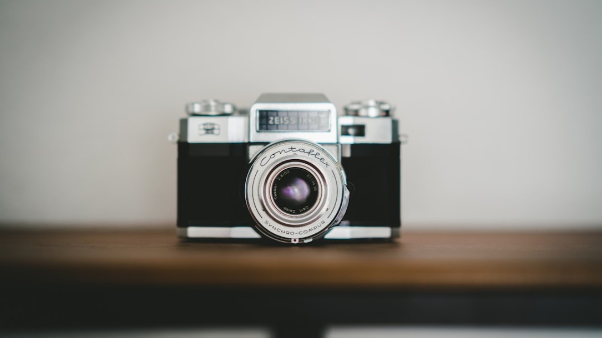 black and silver camera on brown wooden table