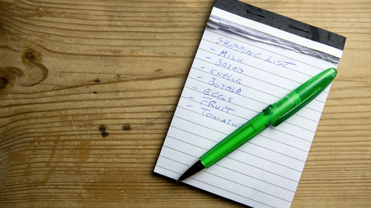 a notepad with a green pen sitting on top of it
