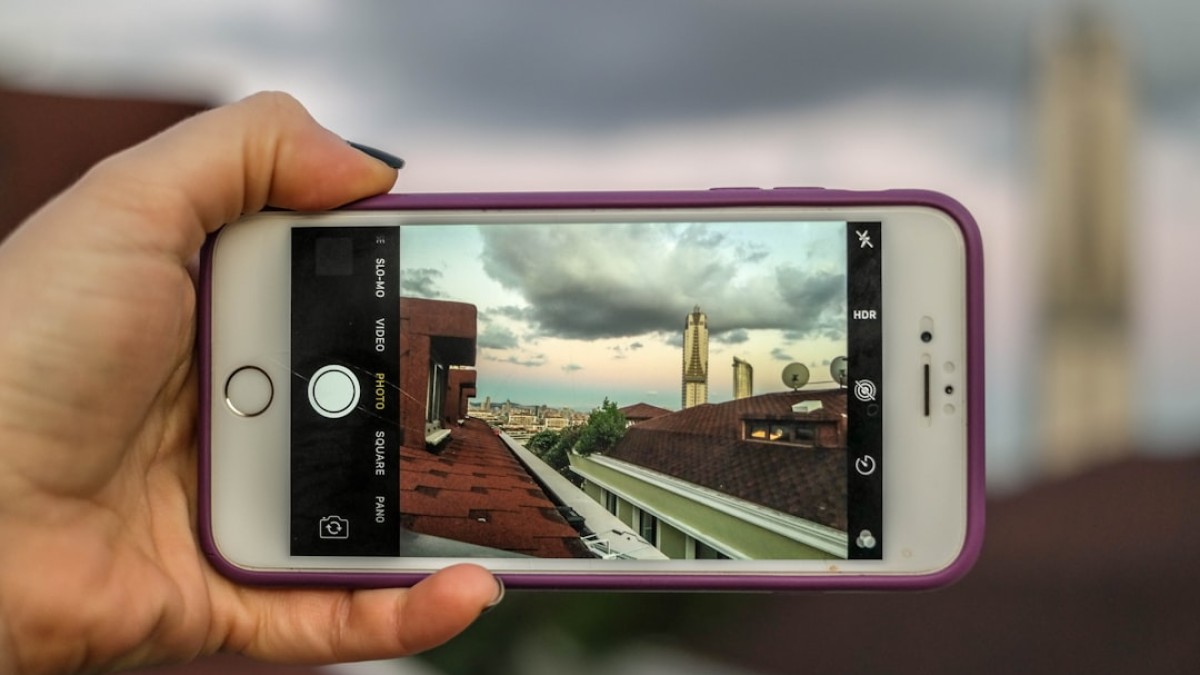 person holding silver iphone 6 with purple case