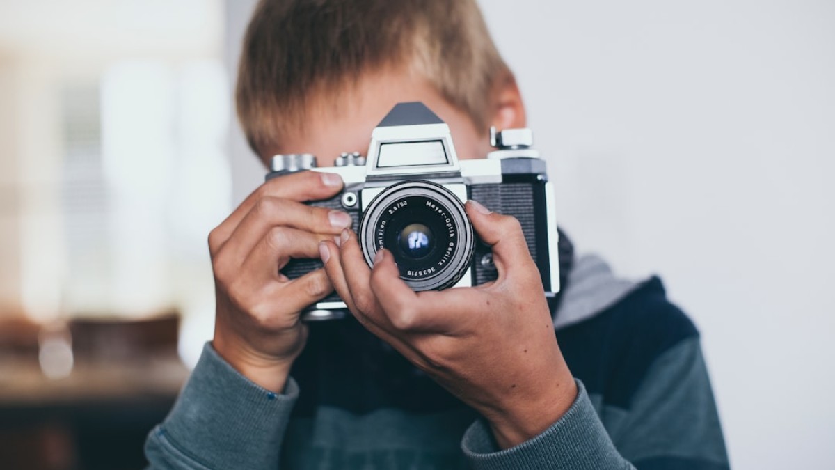 boy holding gray camera